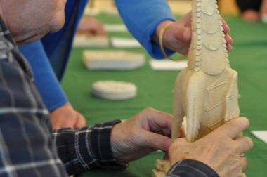 Homme déficient visuel touchant une statut gargouille lors d'un atelier