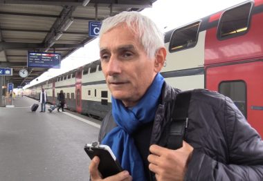 Pierre, déficient visuel, sur le quai d'une gare avec son smarthphone