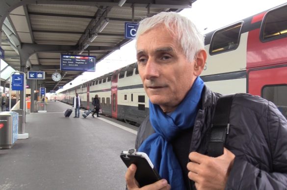 Pierre, déficient visuel, sur le quai d'une gare avec son smarthphone