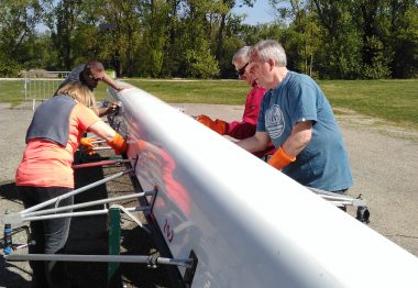 Des déficients visuels entretiennent le dessous d'un aviron