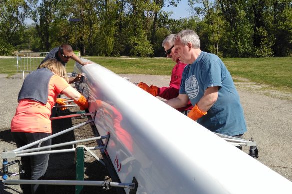 Des déficients visuels entretiennent le dessous d'un aviron