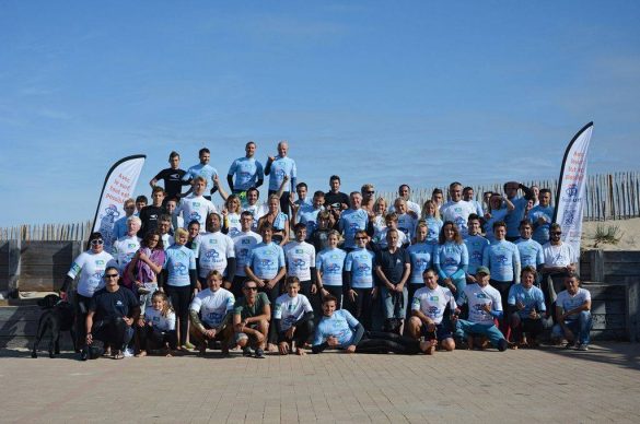 Groupe de benevoles et surfeurs sur la plage.