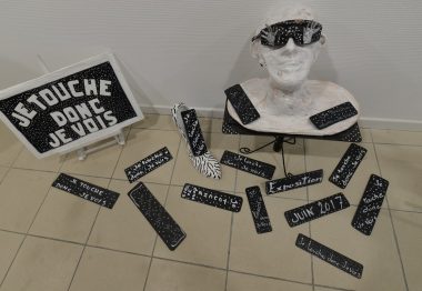 Sculpture d'un buste en papier maché blanc et lunettes noires.