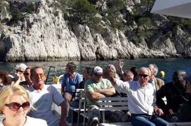 Groupe de bénéficiaires assis sur un bateau dans les calanques de Cassis. 