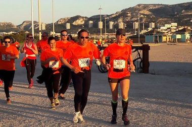 Course en binome de bénéficiaires portant tous un t-shirt orange pendant la Nocturne de Marseille