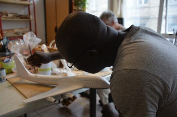 Un bénéficiaire travaille sur la maquette de son Boeing 747.