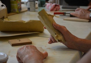 Mains qui travaillent le bois avec du papier de verre