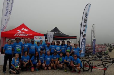 Le groupe de sportifs du triathlon pose devant le stand UNADEV et ISVHN avant la course