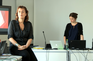 Anne sarah assise dans une salle de cours face à des élèves adultes. 