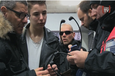 Personnel du stade qui remet un casque à nos bénéficiaires dans les tribunes du stade