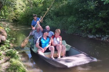 Nos cyclistes assis dans barque sur marais.