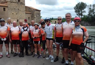 Tous les cyclistes debout devant une rembarde près d'une rivière