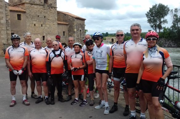 Tous les cyclistes debout devant une rembarde près d'une rivière