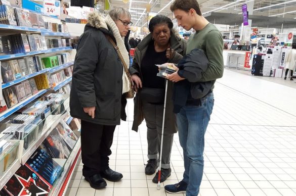 Damien auxiliaire de vie et un couple de malvoyants au rayon CD 