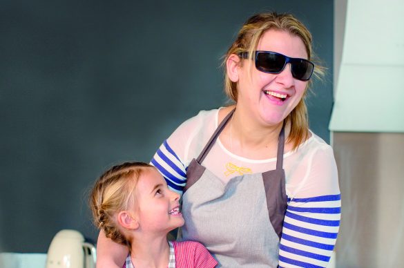 Femme déficiente visuelle faisant de la patisserie avec une enfant