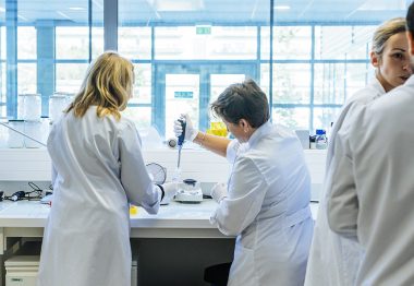 Groupe de chercheurs effectuant des manipulations dans un laboratoire