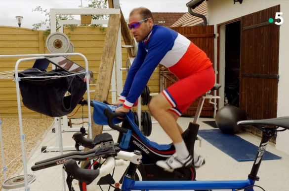 Rapahael sur un velo d'entrainement sur sa terrasse